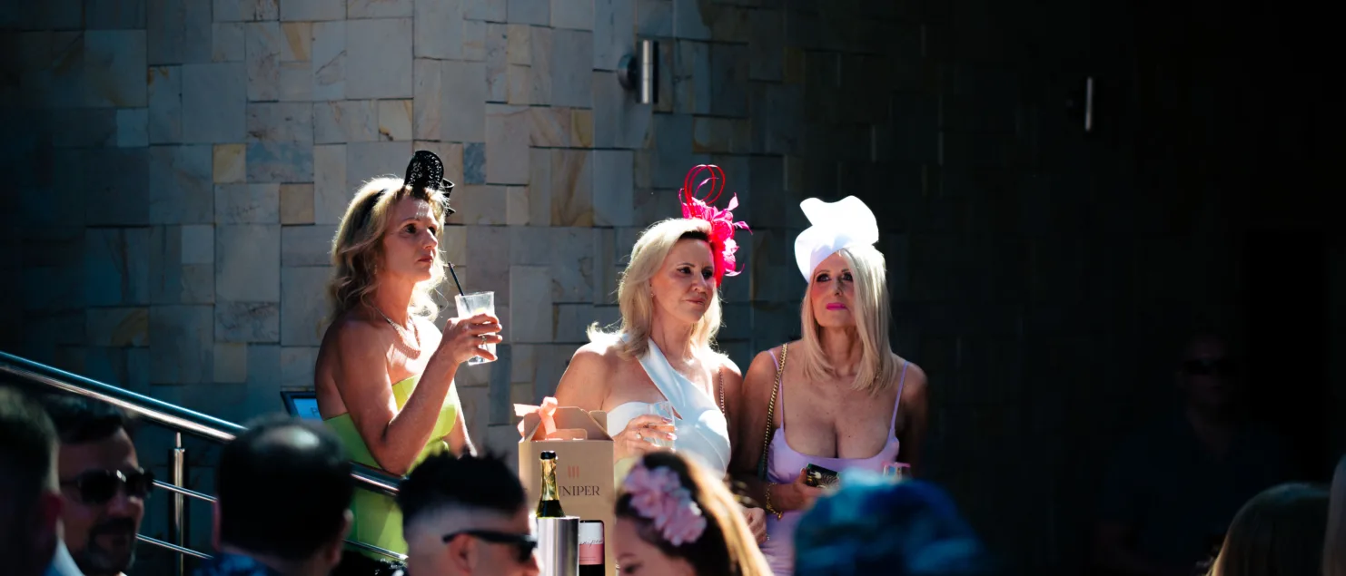 Three ladies in melbourne cup attire listening to music at empire bar in lathlain