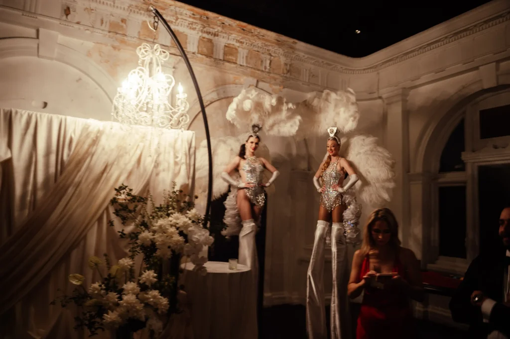 Blurry aesthetic style photo of two stilt dancers with fether wings.